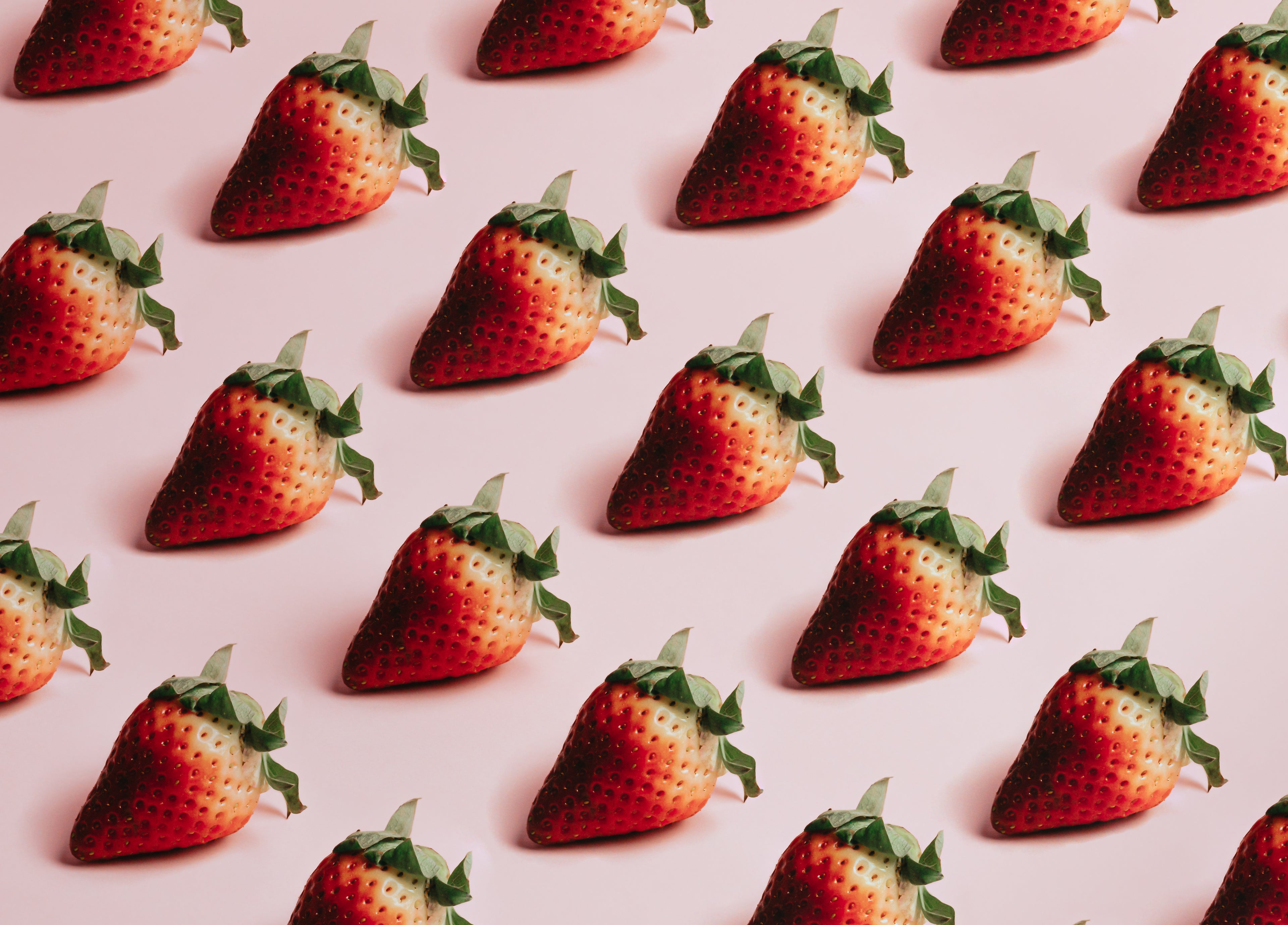 Several strawberries on pink background